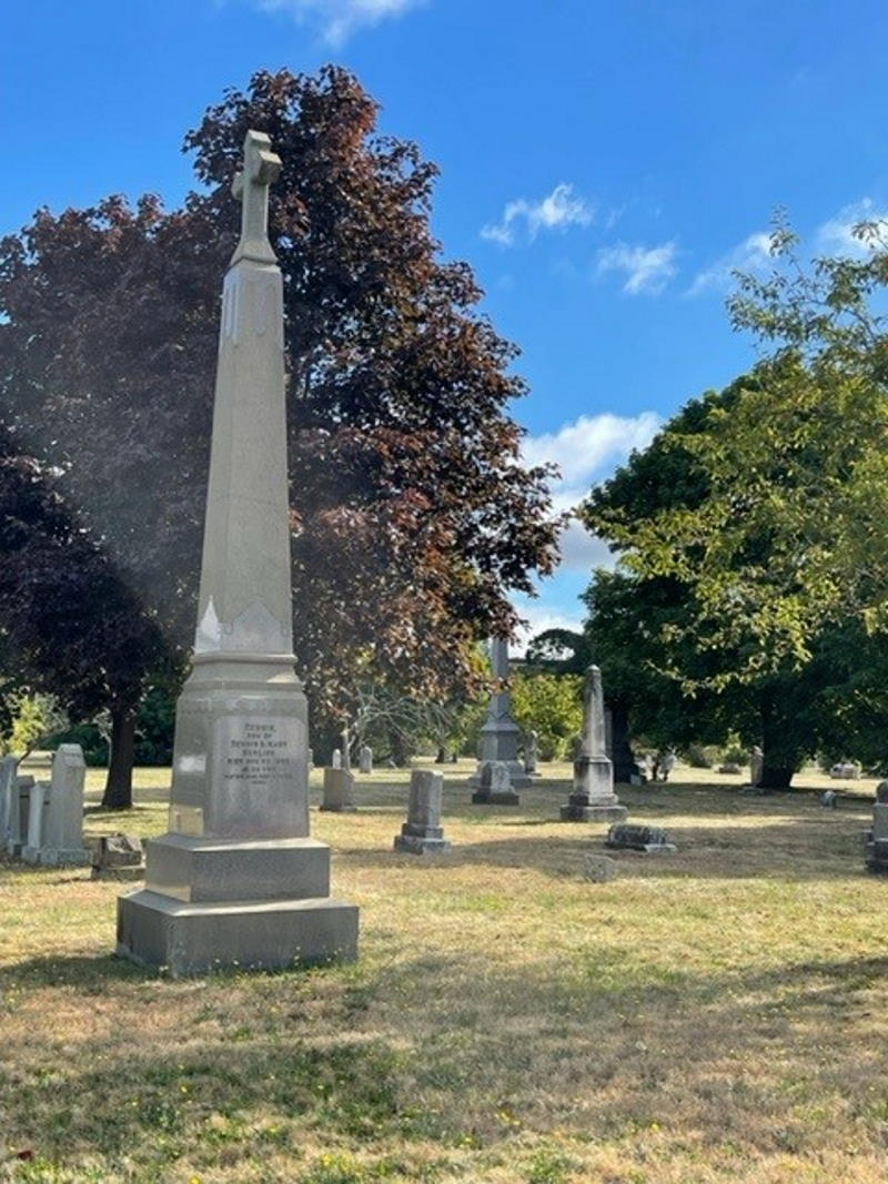 Obelisk topped with a cross under a blue sky