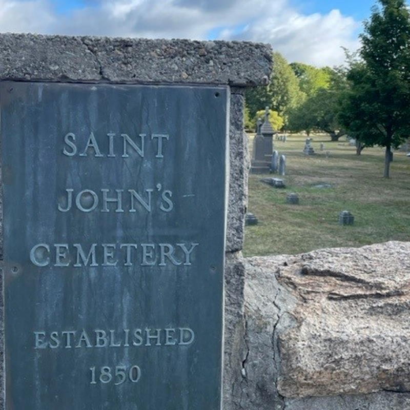 Sign on stone fence reading "Saint John's Cemetery, Established 1850"